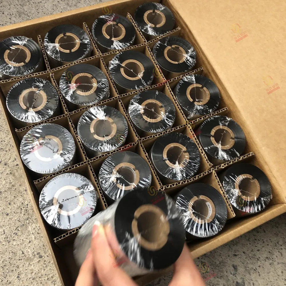Thermal transfer wax resin ribbon rolls, close-up of black reels in cardboard tray