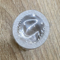 Single circular self-adhesive stamp with clear rim and gray backing
