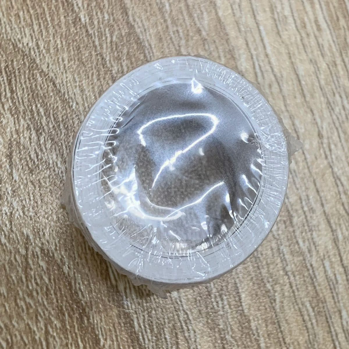 Single circular self-adhesive stamp with clear rim and gray backing