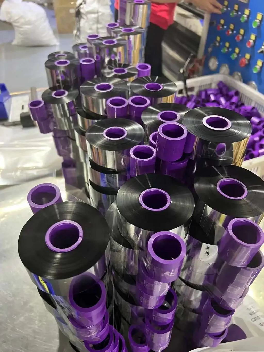 Stacked black wax-resin thermal transfer ribbon rolls with purple inner cores