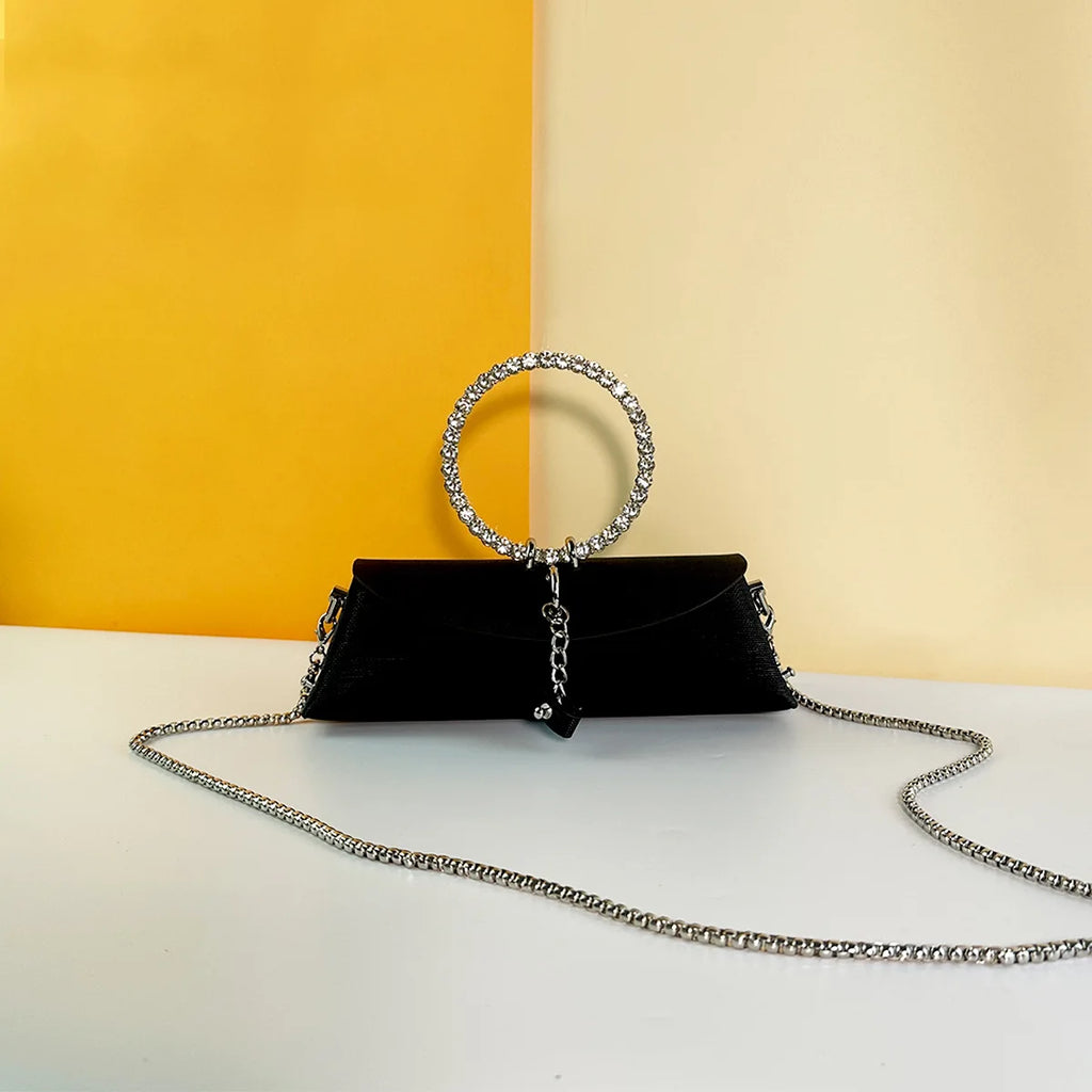 Black luxury clutch bag with rhinestone ring handle, silver chain strap, and elegant evening design for weddings.