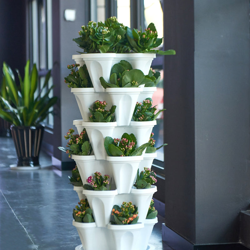 Stackable vertical plastic planter tower with white pots holding green plants