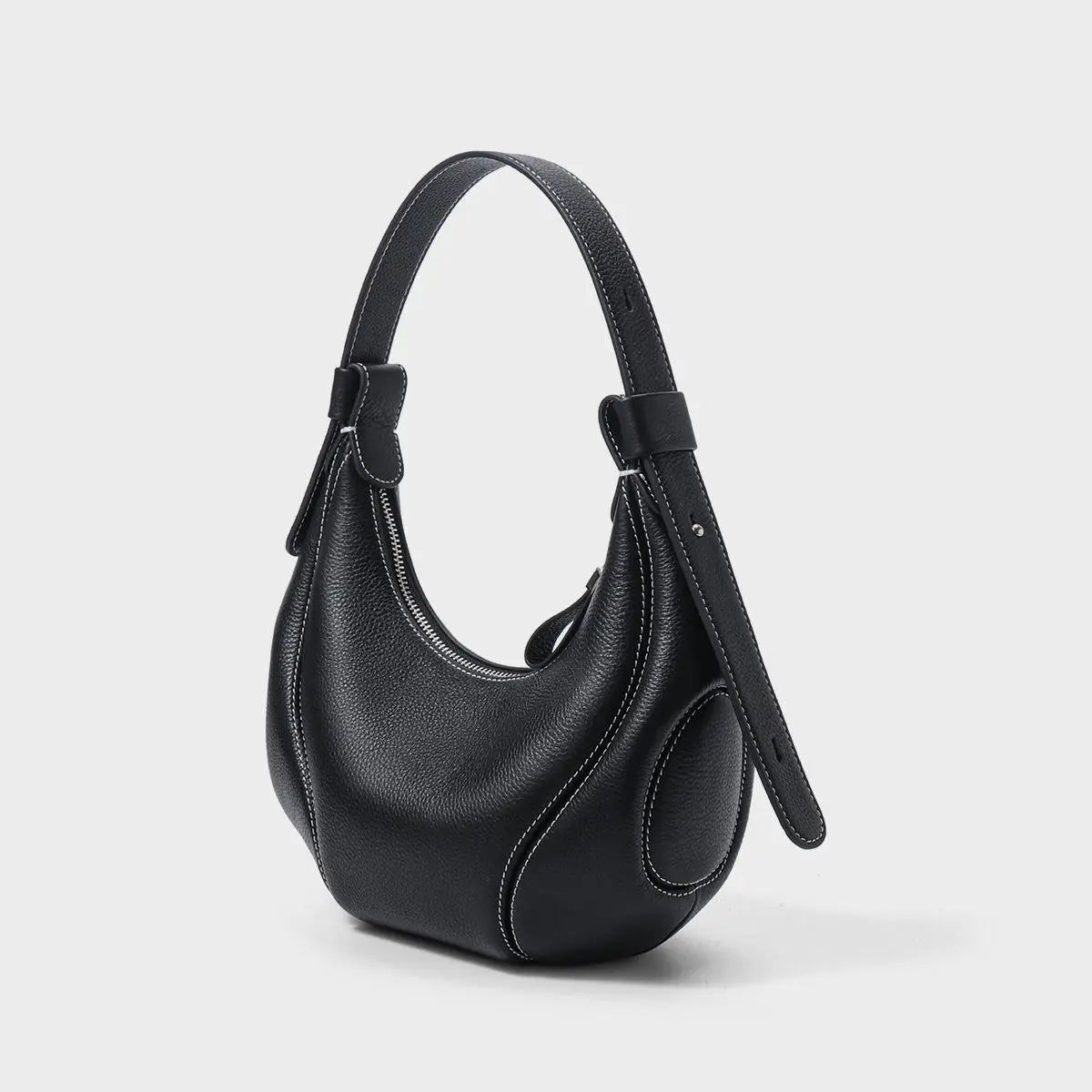 Black pebbled leather half-moon crossbody bag with white contrast stitching, shoulder strap, and zipper closure.