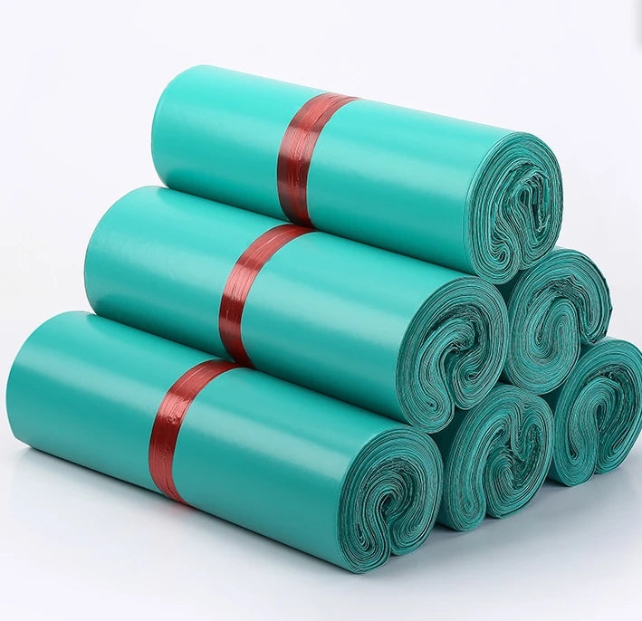 Rolled plastic mailing bags, teal, stacked with red securing bands