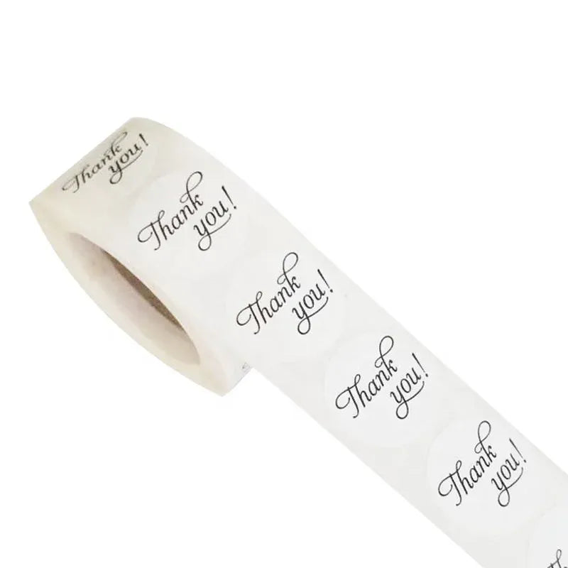 Waterproof thank-you sticker roll on kraft paper, white with black script “Thank you!”