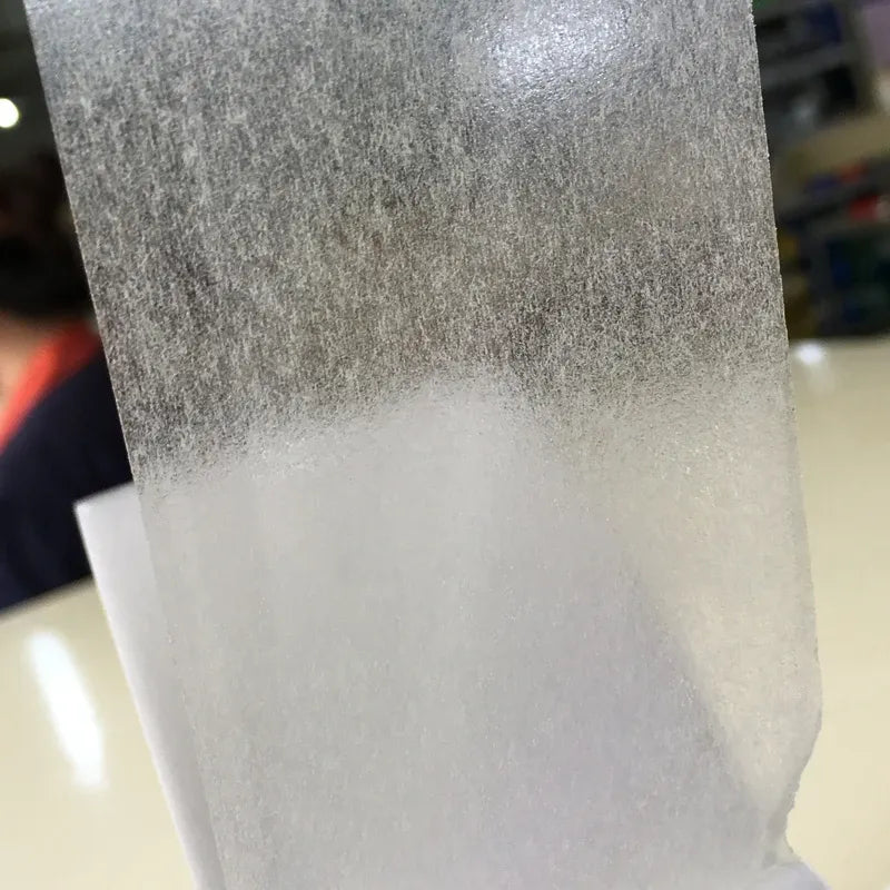 Close-up double-sided tissue tape, textured translucent surface and white adhesive backing