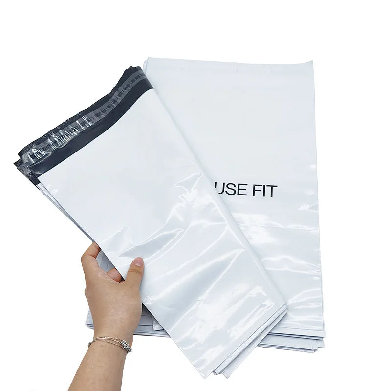 White poly mailer bags with black logo text, held stack with dark seal side