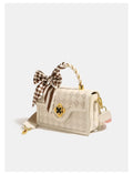 Beige plaid luxury leather trunk handbag with gold clasp, top handle, and brown checkered silk scarf accessory.