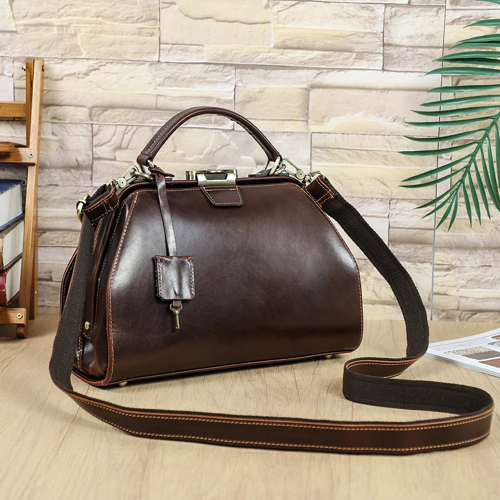 Vintage brown full-grain leather doctor satchel handbag with brass lock, top handle, and adjustable crossbody strap.