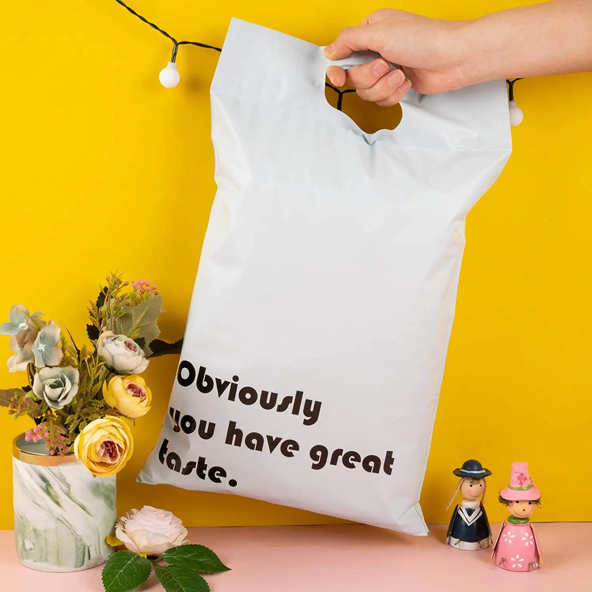 White plastic mailing bag with handle cutout and “Obviously you have great taste.” text
