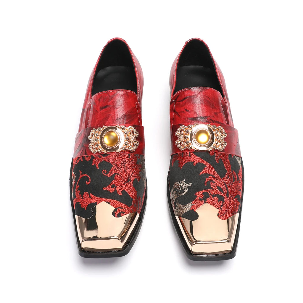 Luxury red patterned leather loafers with gold metal toe cap and ornate hardware detail on a black sole.
