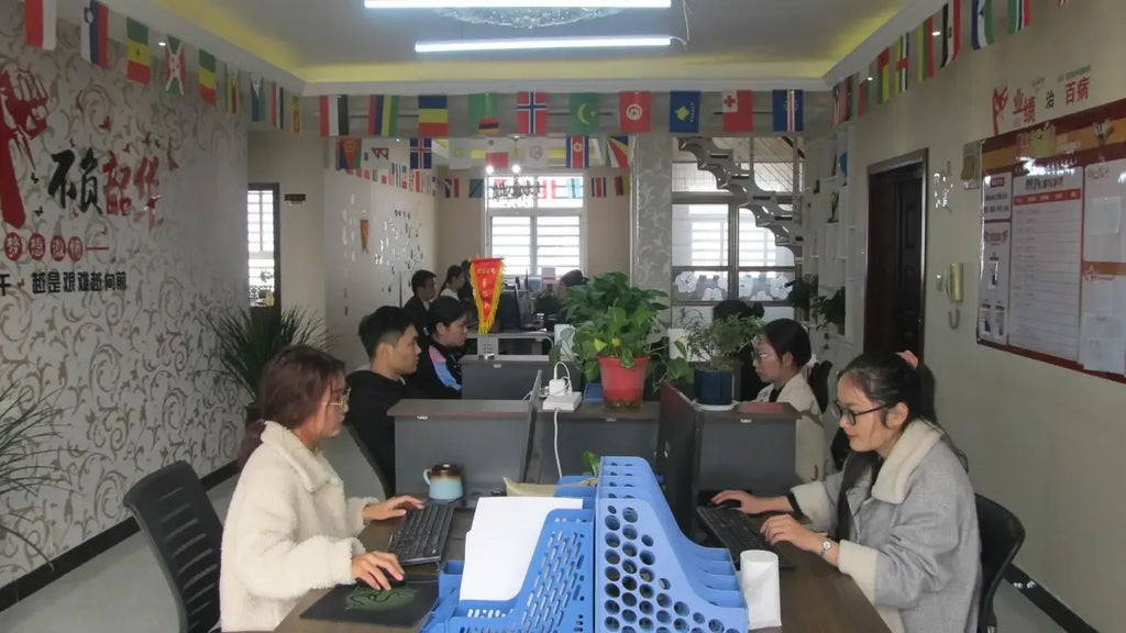 Office meeting room with several people seated at desks, using computers
