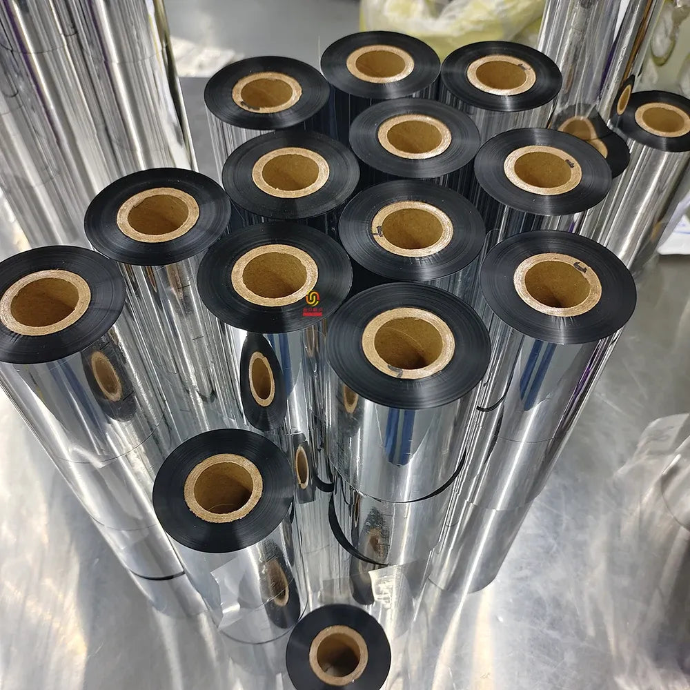Multiple black resin thermal transfer ribbon rolls with tan cores, stacked in rows