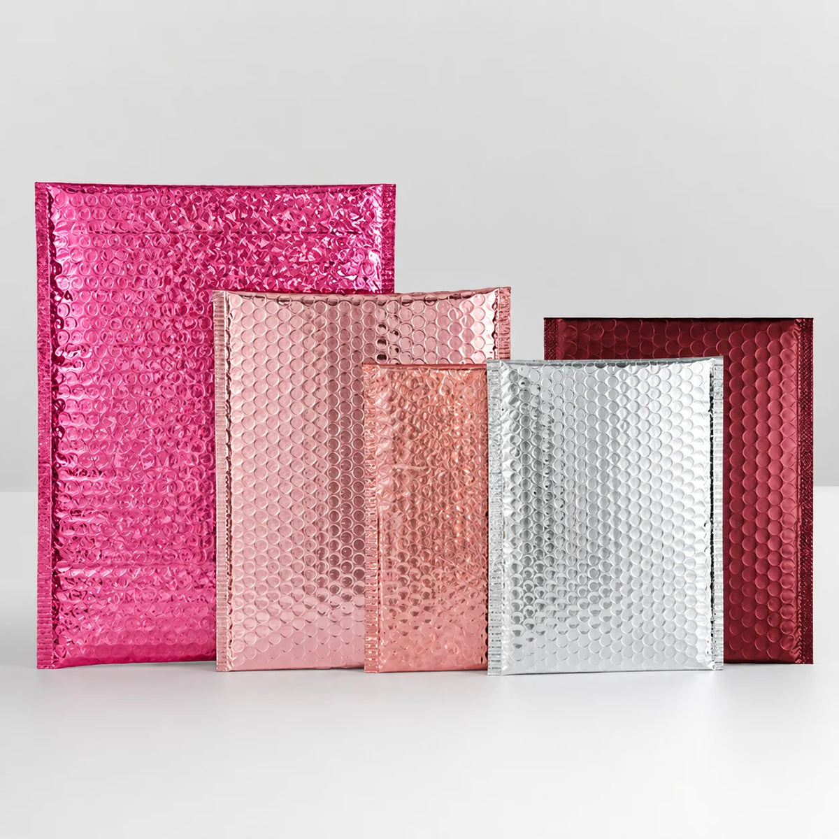 Set of metallic padded bubble mailers in pink, rose gold, silver, tan, and dark red
