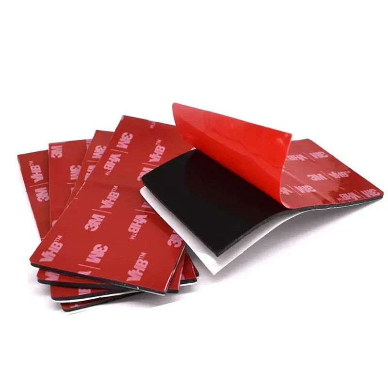Stack of red 3M VHB double-sided acrylic foam tape pads with black backing