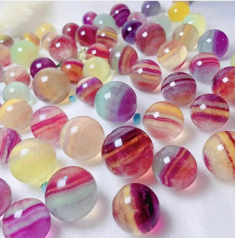 Fluorite crystal spheres, close-up of glossy round stones in pink, purple, yellow