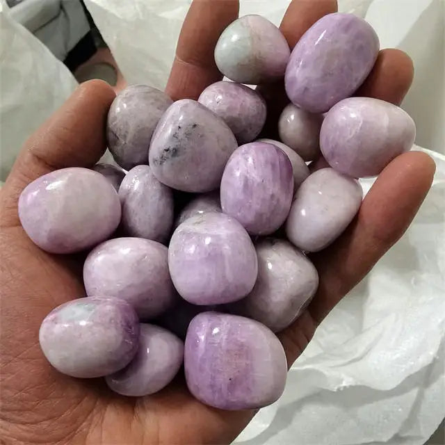 Purple kunzite tumbled stones, rounded polished rocks in a handful