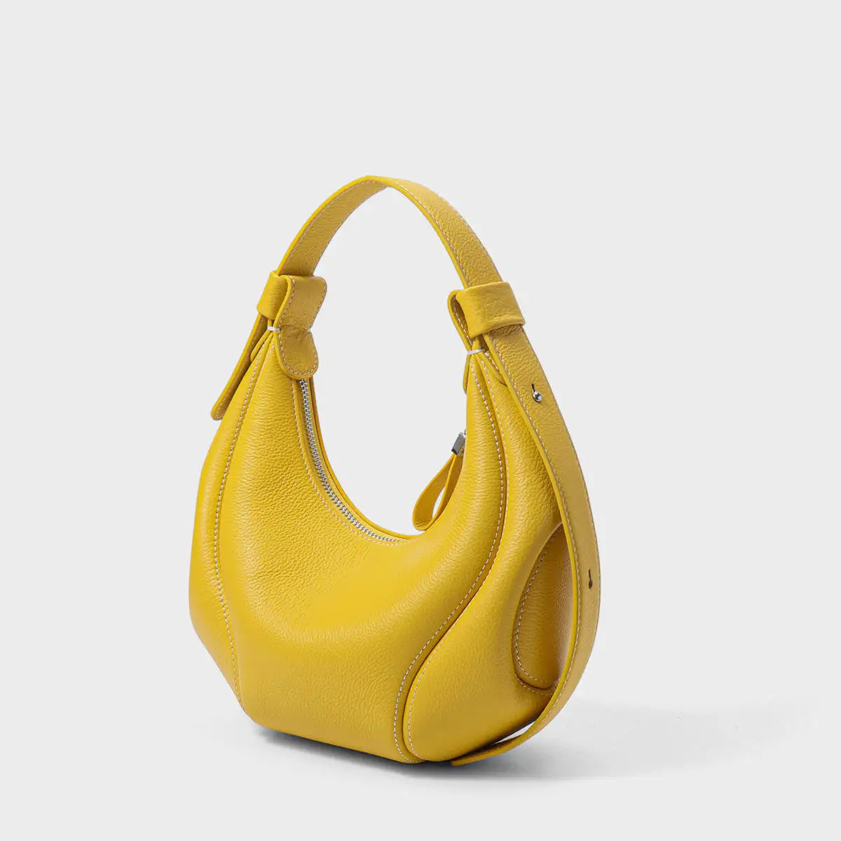 Yellow half-moon luxury leather handbag with pebbled texture, white stitching, and a short shoulder strap.