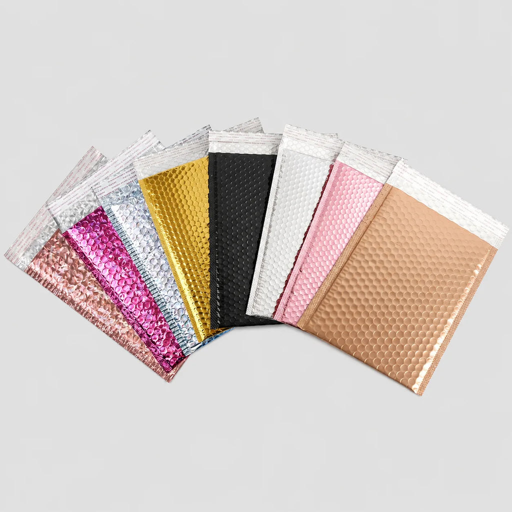 Assorted metallic bubble mailer shipping bags in pink, yellow, black, white, and gold