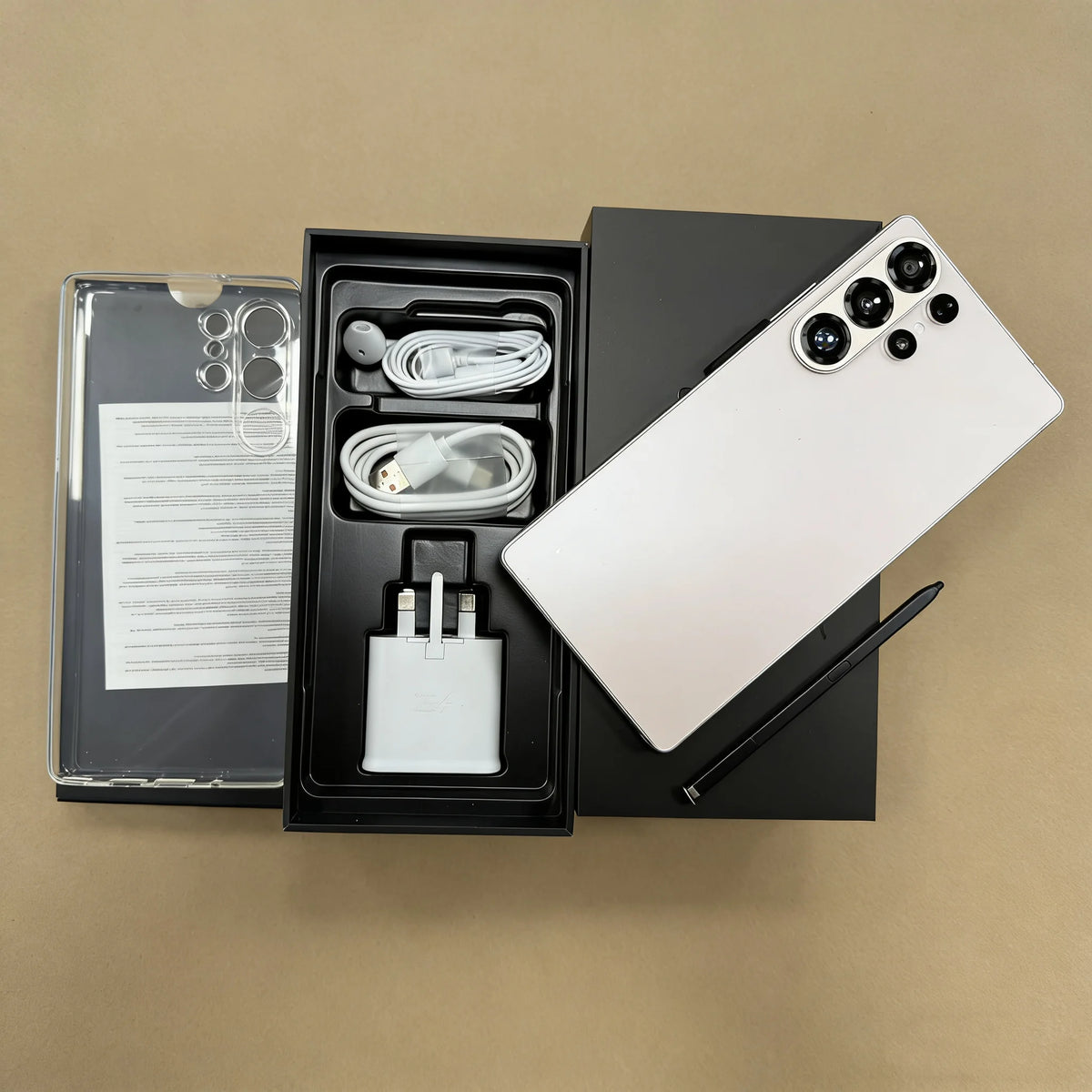 Unlocked smartphone in white with four rear cameras; open package with cables and adapter