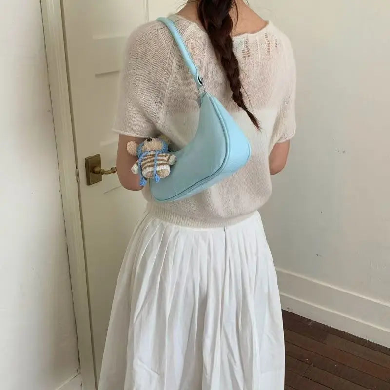 Light blue leather dumpling-shaped shoulder bag with charm, styled as a chic waterproof crossbody accessory.