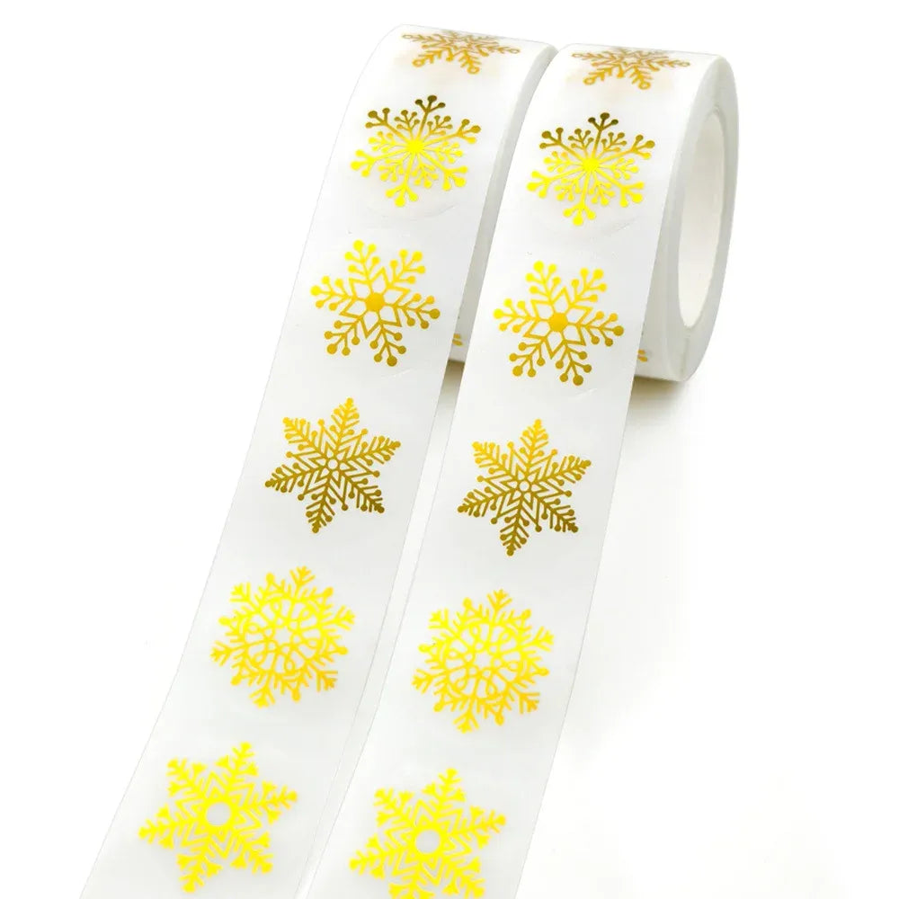Roll of round snowflake stickers with yellow foil print, transparent self-adhesive label backing.