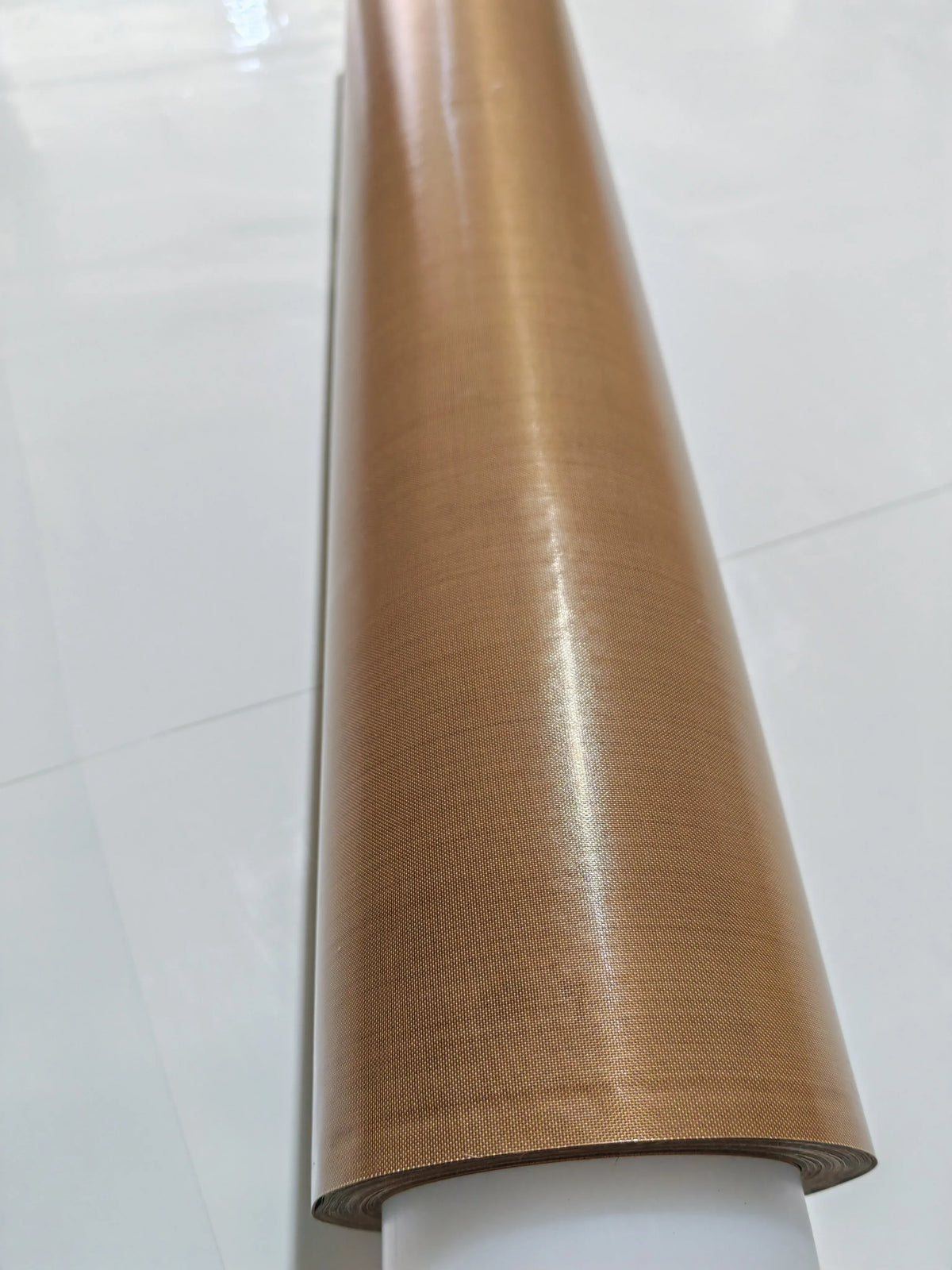 Brown PTFE tape roll with smooth wound layers and visible roll edge