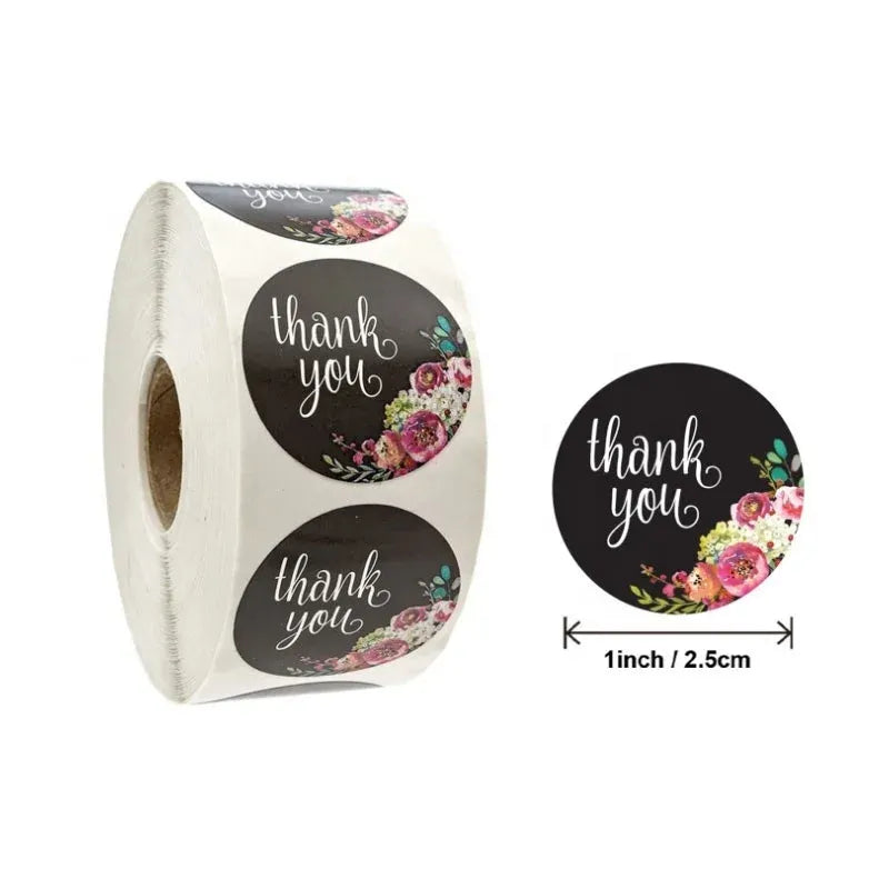 Roll of circular thank you stickers with black backgrounds and floral accents
