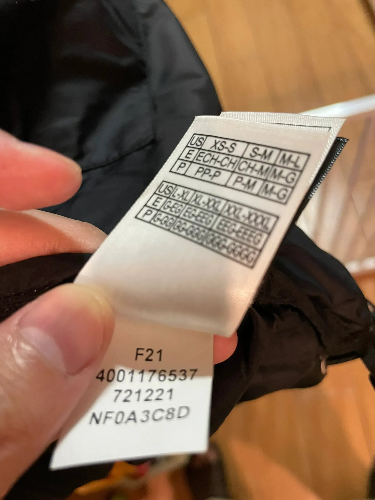 White woven clothing label with barcode, size code, and F21 printing codes