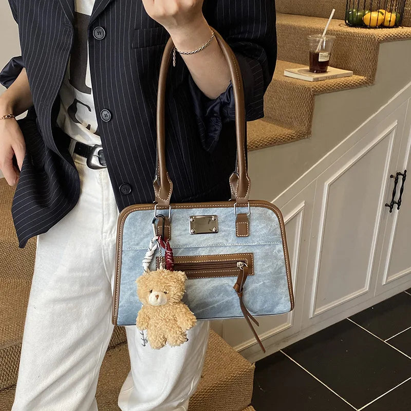 Blue soft faux leather tote bag with brown trim, zipper pocket, and cute teddy bear charm. Stylish large trunk purse.