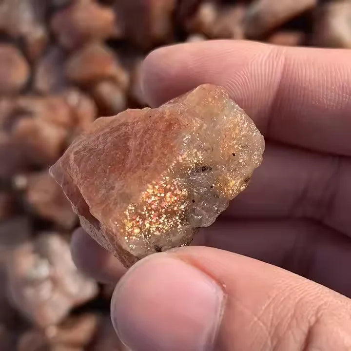 Golden sunstone quartz crystal chunk, rough textured face in hand