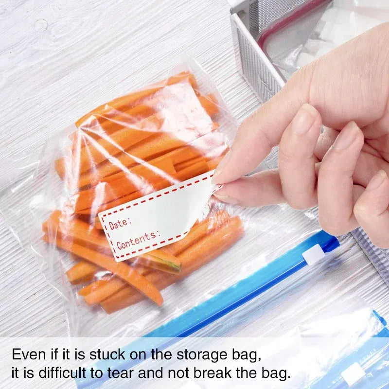 White date-contents sticker being applied to a clear plastic food storage bag