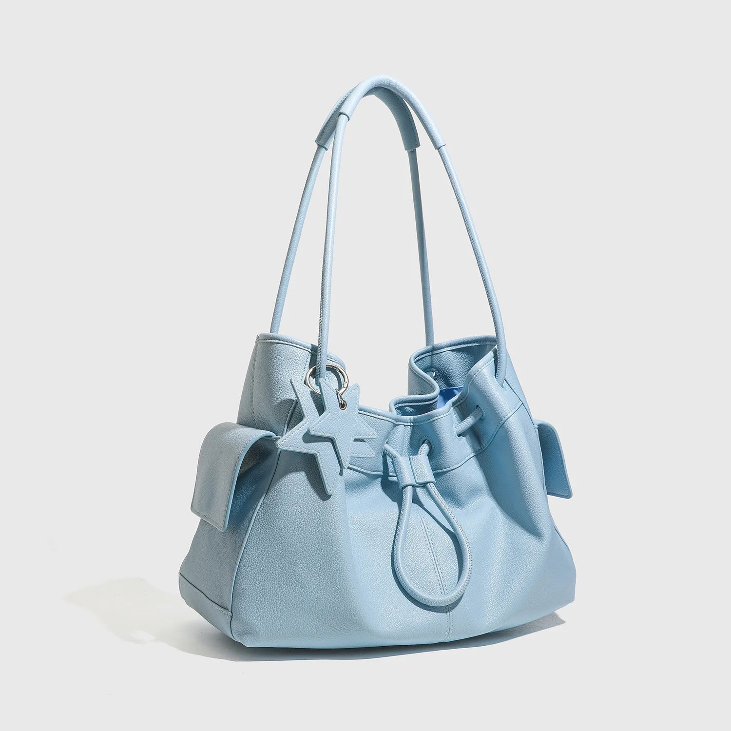 Light blue leather shoulder bag, large capacity commuting handbag with drawstring, two straps, and star charm.