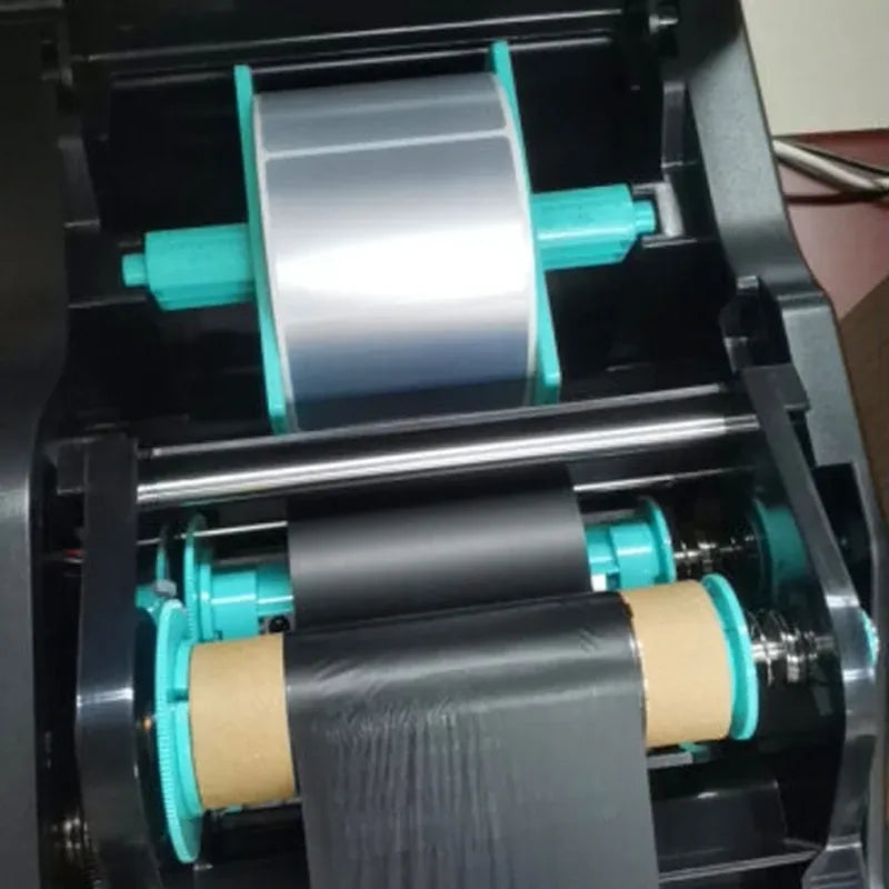 Thermal label printer mechanism loaded with a black ribbon roll
