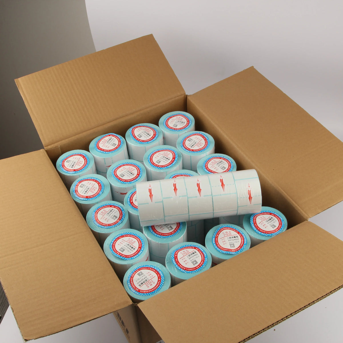 Boxed shipment with multiple sky blue direct thermal label rolls and white label sheets