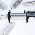 Purple sodalite crystal point tower with digital caliper size measurement