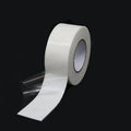 White double-sided foam mounting tape roll with an extended strip