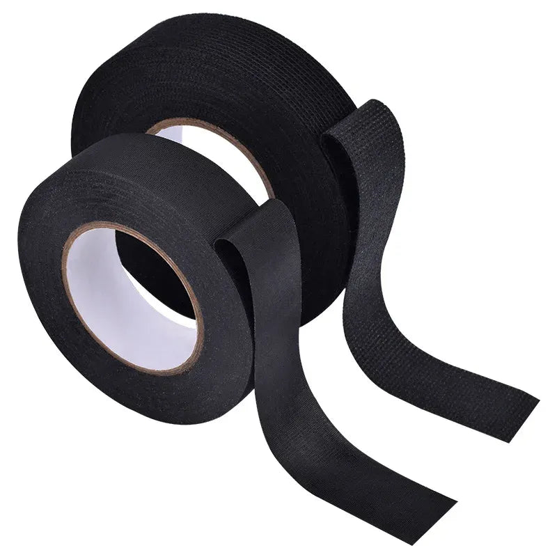 Black fabric insulation tape roll with long strip and paper core visible