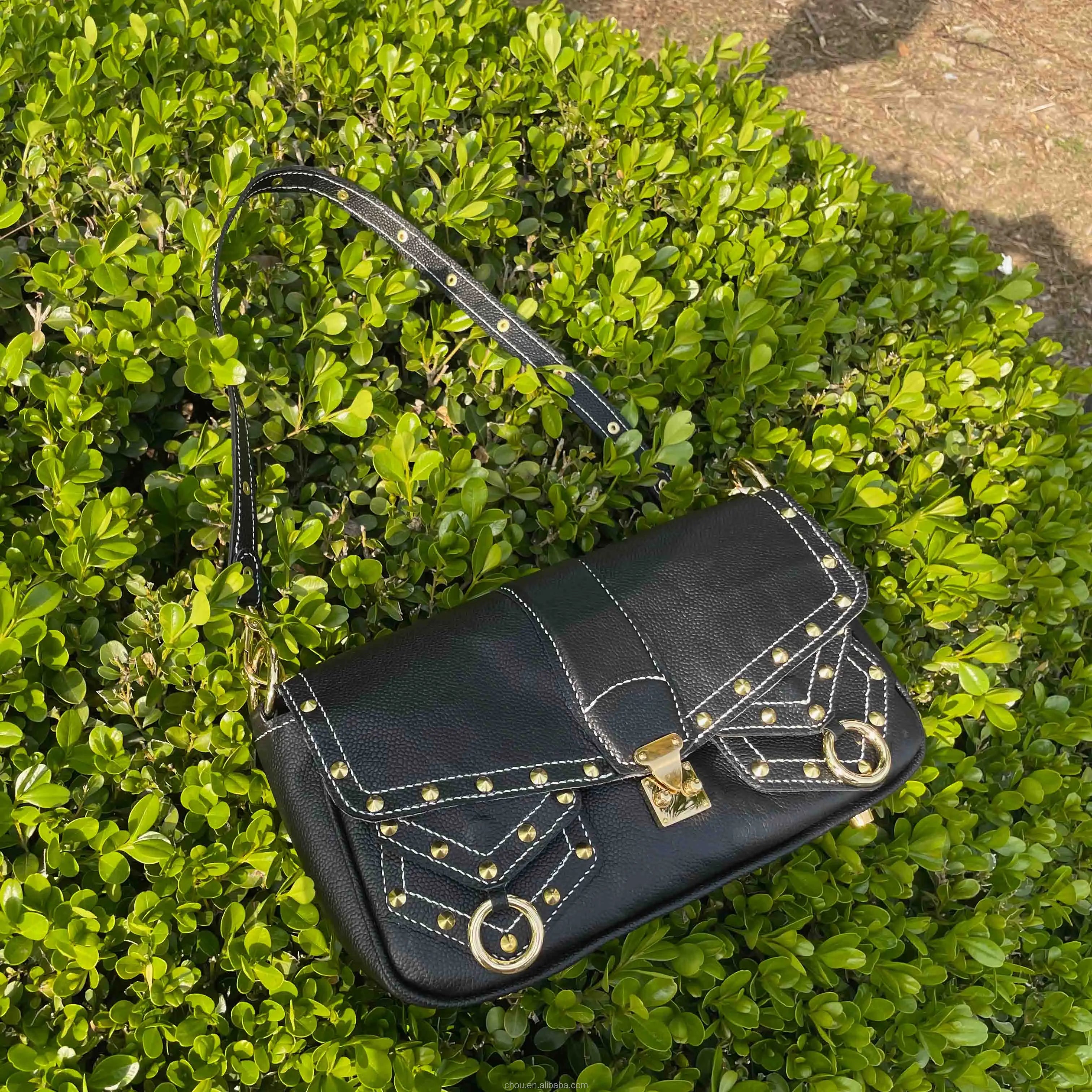 Black calf leather shoulder bag with white contrast stitching, gold stud accents, and a front lock closure. Trunk style.
