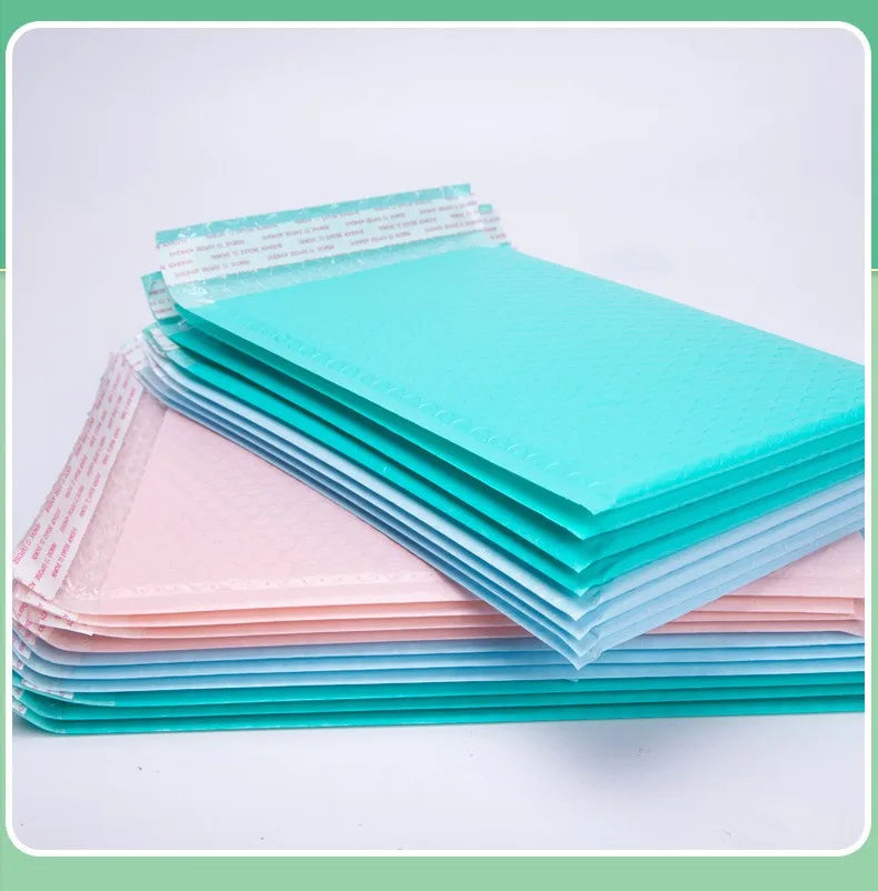 Stack of bubble mailer bags in blue and pink colors, each with self-seal flap