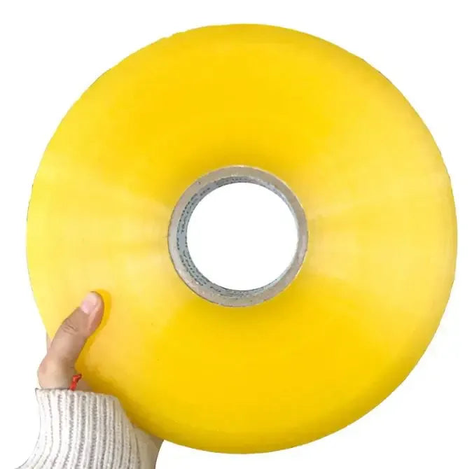 Yellow packing tape roll held in hand, visible inner cardboard core