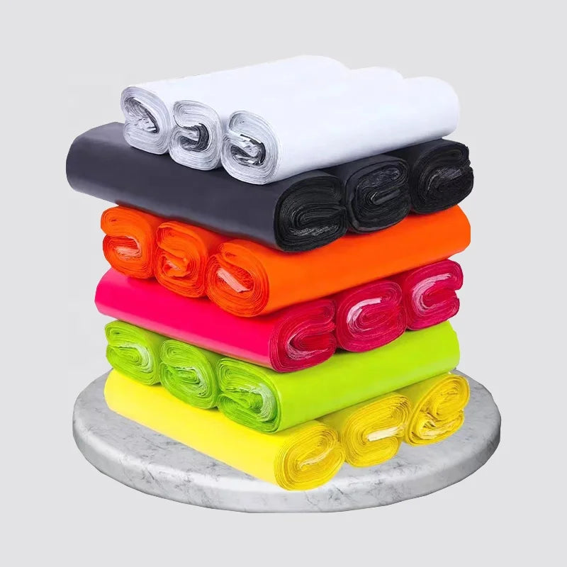 Assorted colored thick poly self-seal shipping mailer rolls: white, black, orange, pink, lime