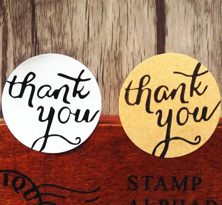 Round adhesive seal stickers with “thank you” script, white and kraft colors.