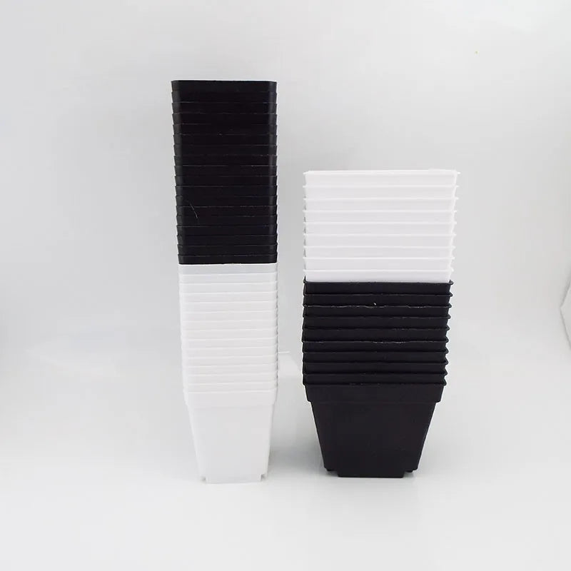 Stacked mini plastic square planter pots in black and white