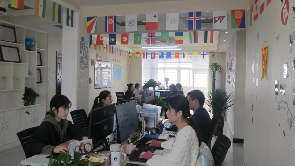 Office workspace with people working at computers around shared desks