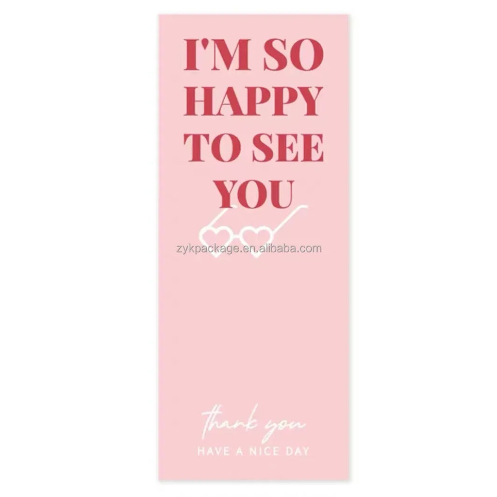 Close-up pink label sticker with “I’m so happy to see you” and “Have a nice day”.