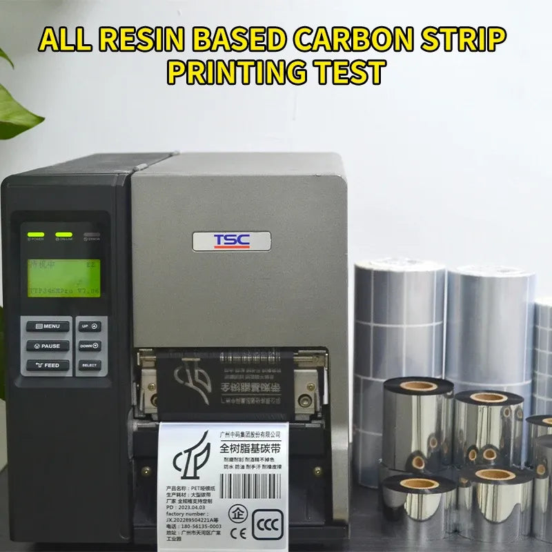 Black thermal transfer ribbon rolls beside thermal printer for label printing tests