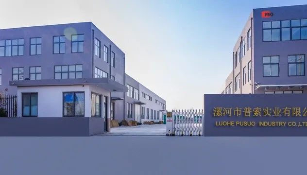 Industrial factory building exterior with fenced entrance and facility signage