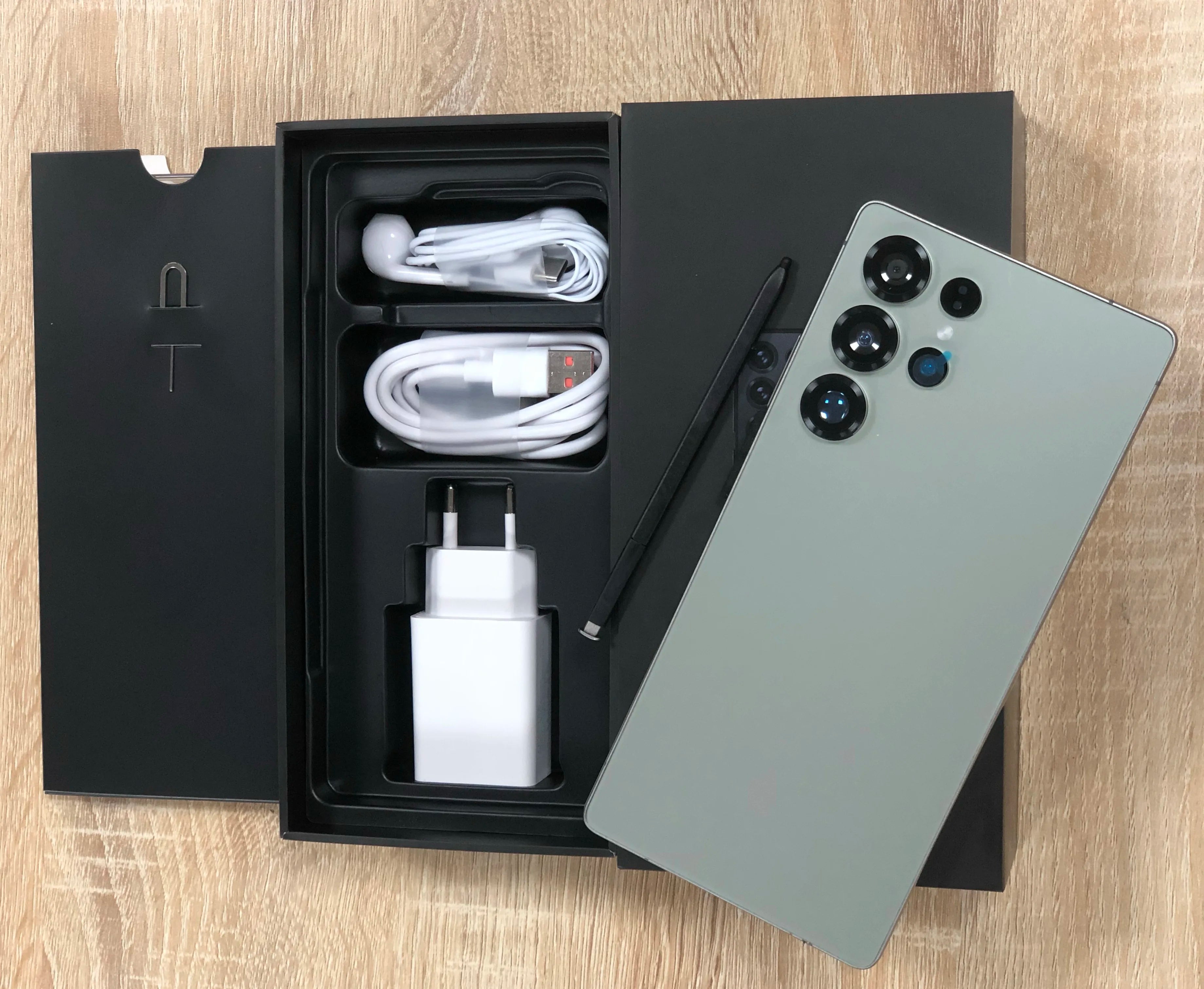 Android smartphone with light green back and quad rear cameras; includes cables and charger