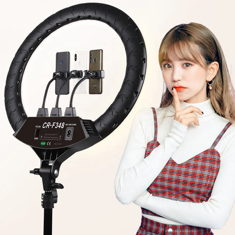 Black circular ring light with three flexible phone holders on a stand for photography and content creation.